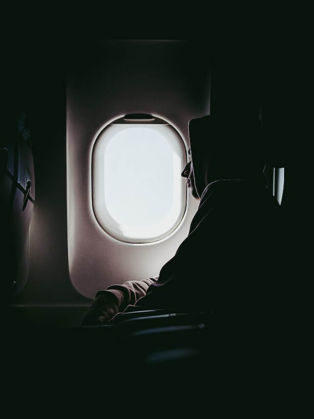 A man in the airplane, looking at the window